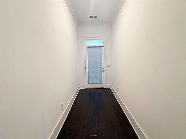 a view of a hallway with wooden floor