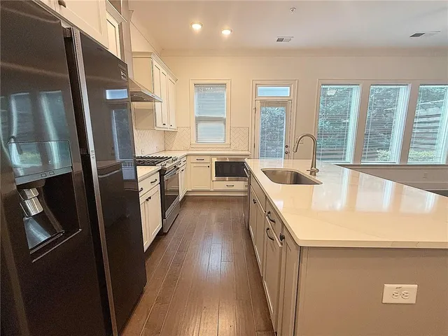a kitchen with a sink a refrigerator a washer dryer and a stove