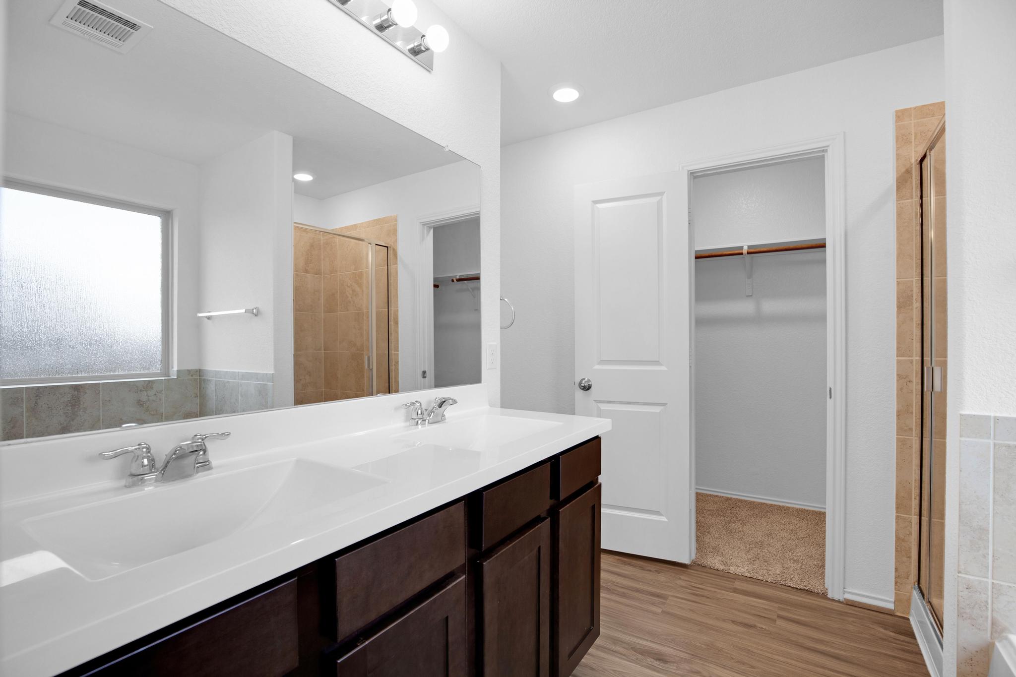 21409 Resource Road Pflugerville, TX 78660 - Photo 12 of 23 Full bath with double vanity, a walk in closet, and a shower stall