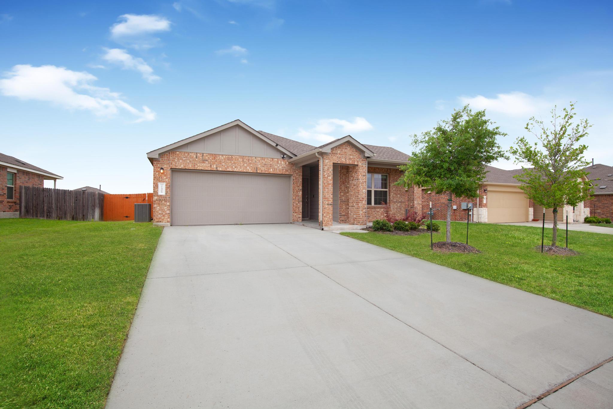21409 Resource Road Pflugerville, TX 78660 - Photo 2 of 23 Single story home featuring a front yard, a garage, driveway, and brick siding