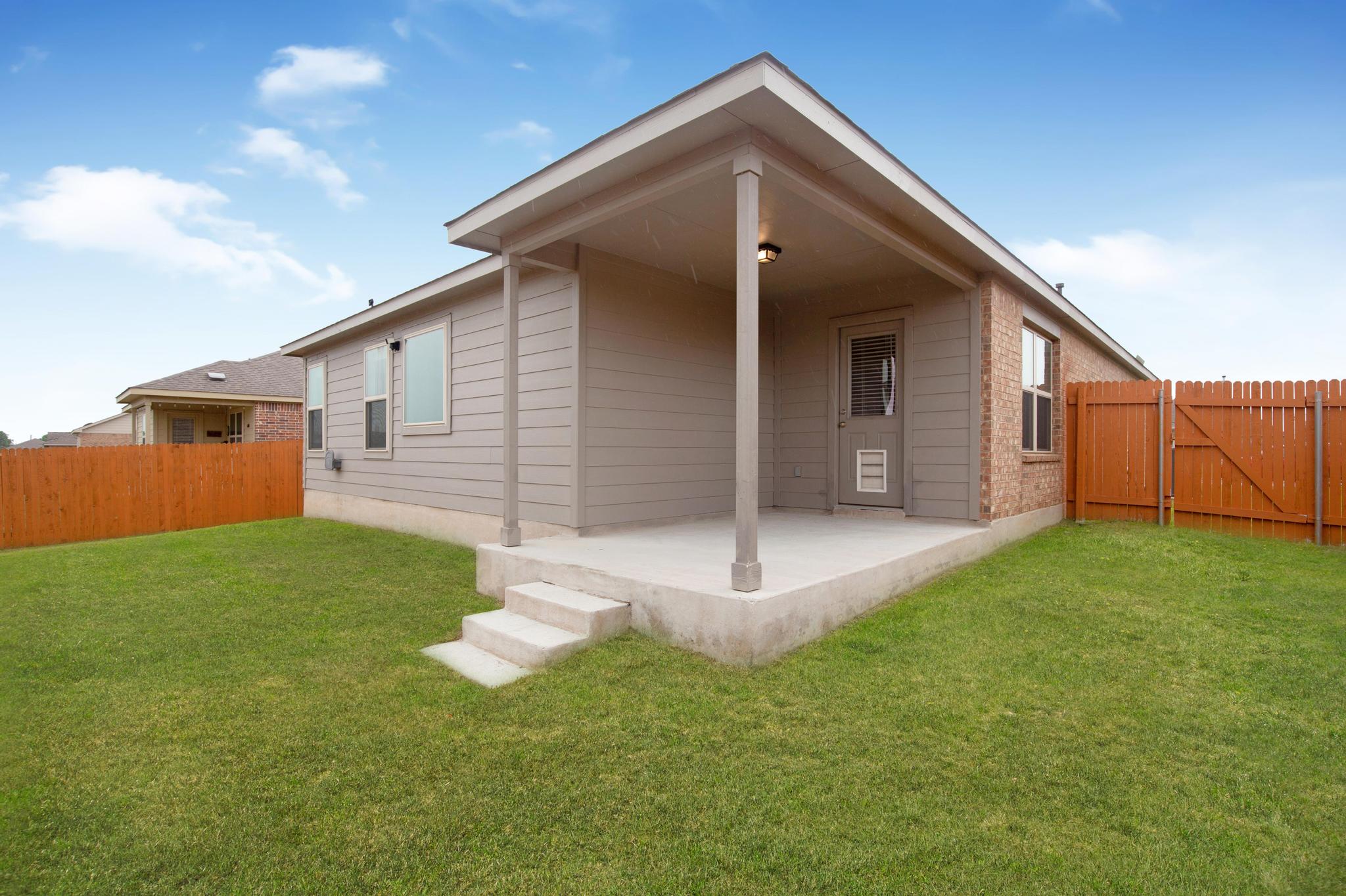 21409 Resource Road Pflugerville, TX 78660 - Photo 22 of 23 Rear view of property with a patio, a gate, and brick siding
