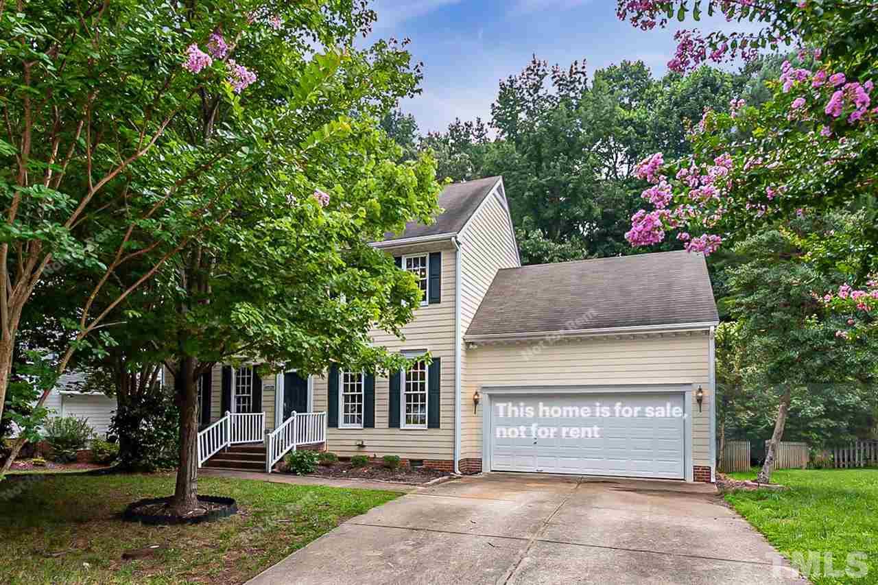 a front view of a house with a yard and a garden