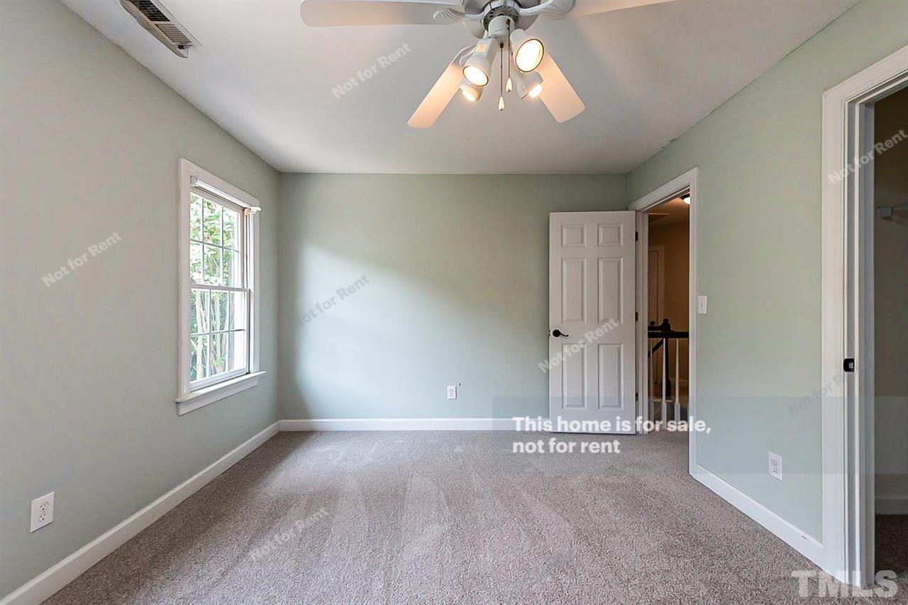 8528 Yucca Trail Raleigh, NC 27615 - Photo 17 of 21 an empty room with chandelier fan and windows
