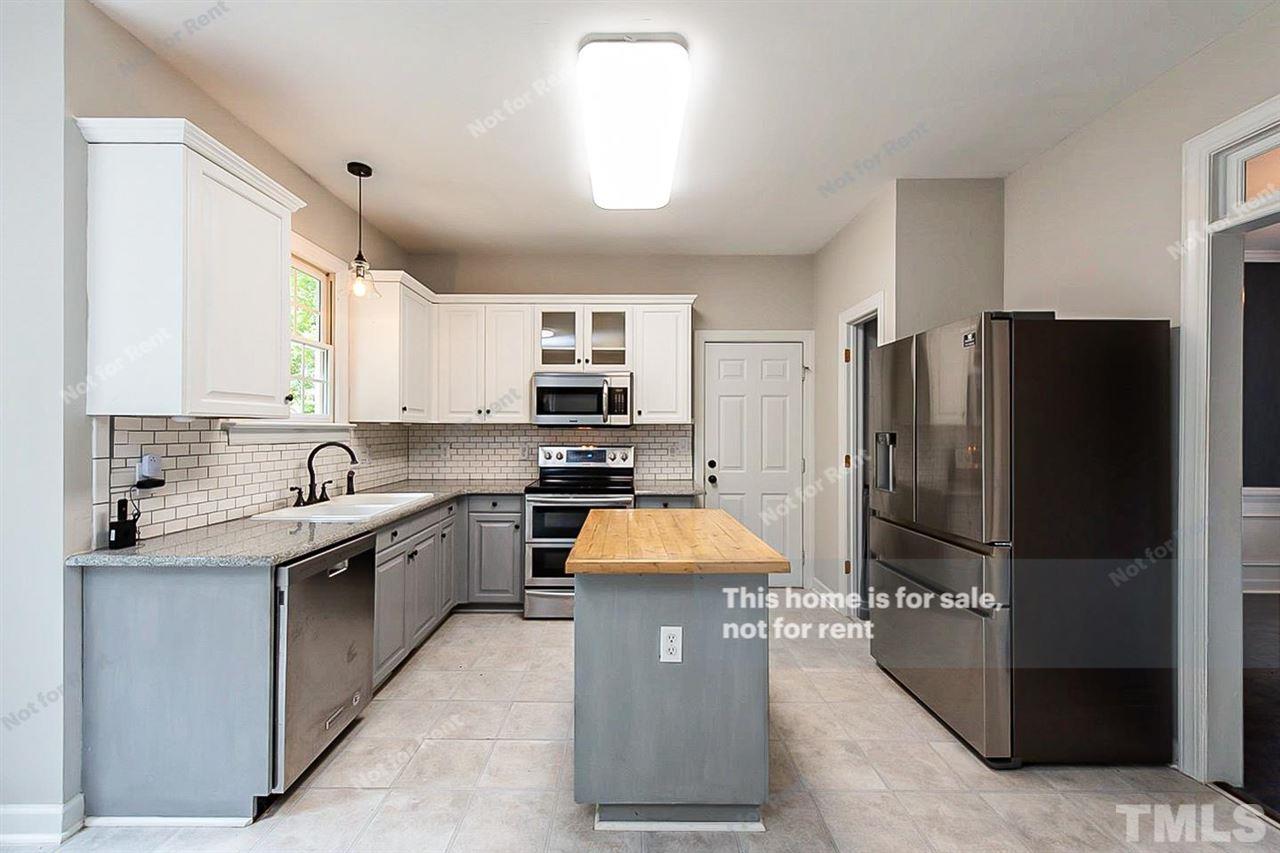 8528 Yucca Trail Raleigh, NC 27615 - Photo 4 of 21 a kitchen with stainless steel appliances granite countertop a refrigerator a stove and a sink