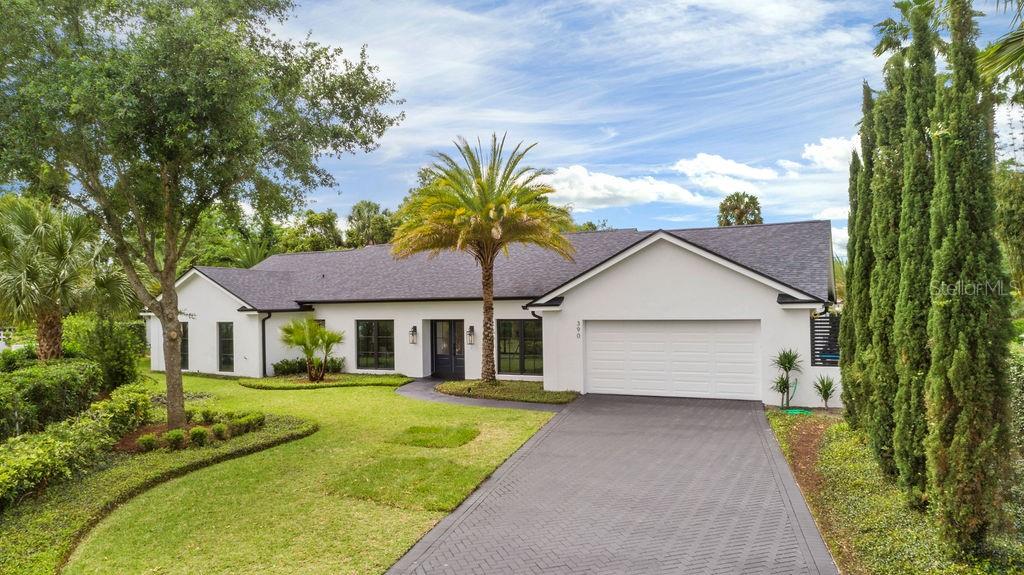 390 Waterfall Lane Winter Park, FL 32789 - Photo 1 of 1 a front view of a house with a garden and trees