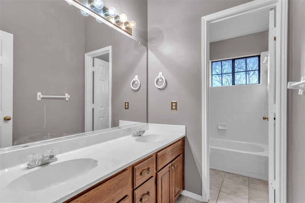 6613 Springmeadow Lane Rowlett, TX 75089 - Photo 16 of 20 a spacious bathroom with a granite countertop sink a mirror and a bathtub