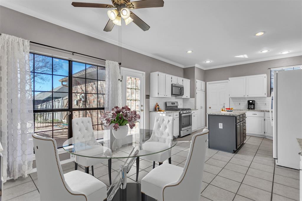 6613 Springmeadow Lane Rowlett, TX 75089 - Photo 5 of 20 a kitchen with stainless steel appliances kitchen island granite countertop a refrigerator a stove a sink dishwasher with a dining table and chairs