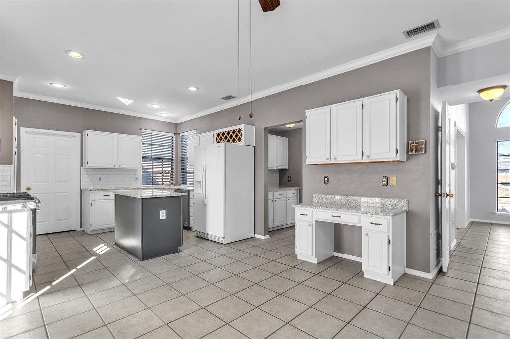 6613 Springmeadow Lane Rowlett, TX 75089 - Photo 7 of 20 a kitchen with white cabinets and refrigerator