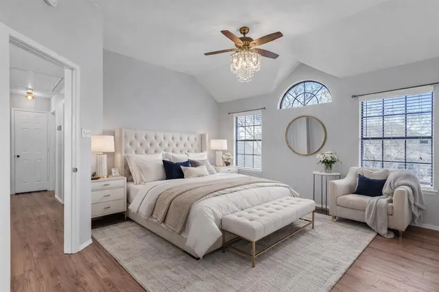 a bedroom with a large bed and a chandelier