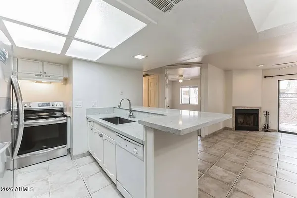 a kitchen with granite countertop a sink stove and cabinets
