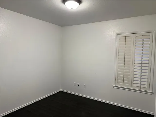 a view of a small space with wooden floor and a window