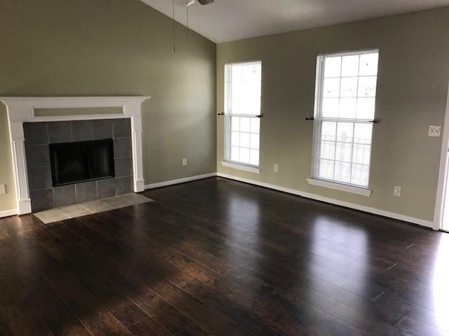 4086 Parks Road Flowery Branch, GA 30542 - Photo 4 of 23 an empty room with wooden floor fireplace and windows