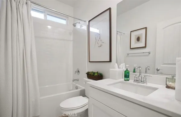 a bathroom with a granite countertop sink a toilet a large mirror and shower