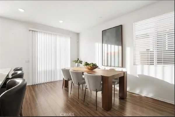 a view of a a dining room with furniture window and wooden floor