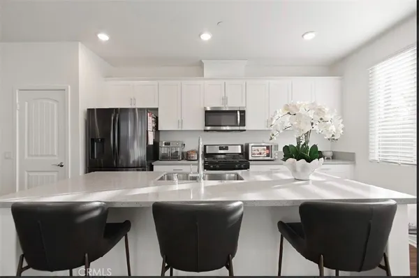 a kitchen with a table chairs refrigerator and microwave