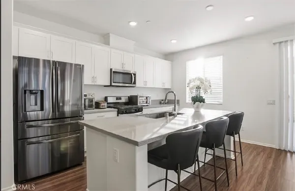 a kitchen with stainless steel appliances a stove a sink a refrigerator and a refrigerator