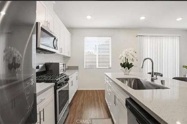 a kitchen with stainless steel appliances kitchen island a stove a sink and a refrigerator