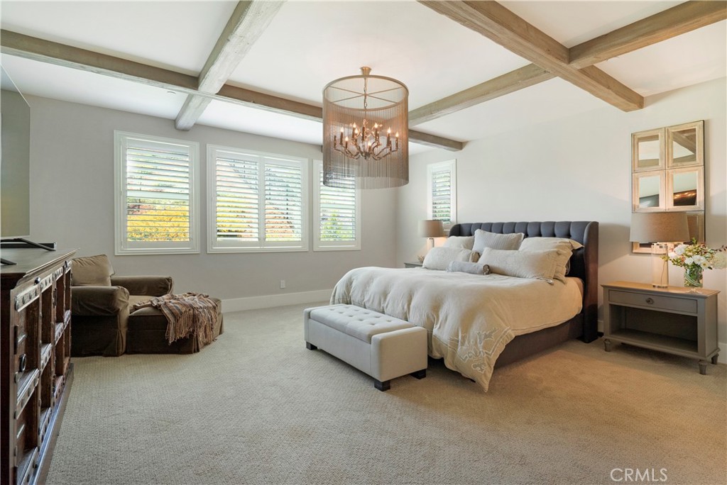 12237 Cortona Place Riverside, CA 92503 - Photo 21 of 60 a spacious bedroom with a bed and a chandelier
