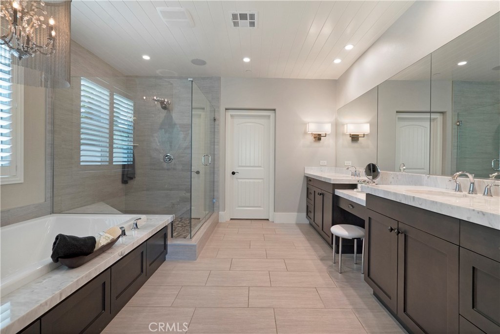 12237 Cortona Place Riverside, CA 92503 - Photo 24 of 60 a large bathroom with a double vanity sink a mirror and a bathtub