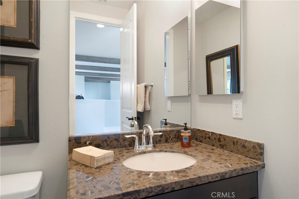 12237 Cortona Place Riverside, CA 92503 - Photo 46 of 60 a bathroom with a granite countertop sink and a mirror with toilet