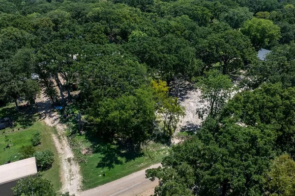 an aerial view of residential house with outdoor space and trees all around