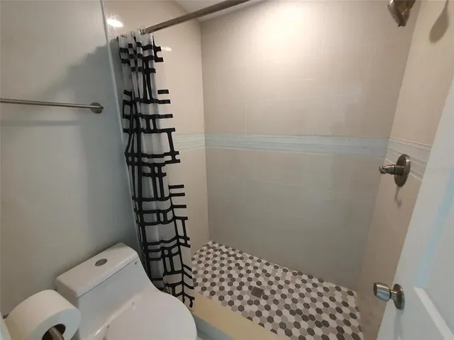 a bathroom with a toilet and a shower