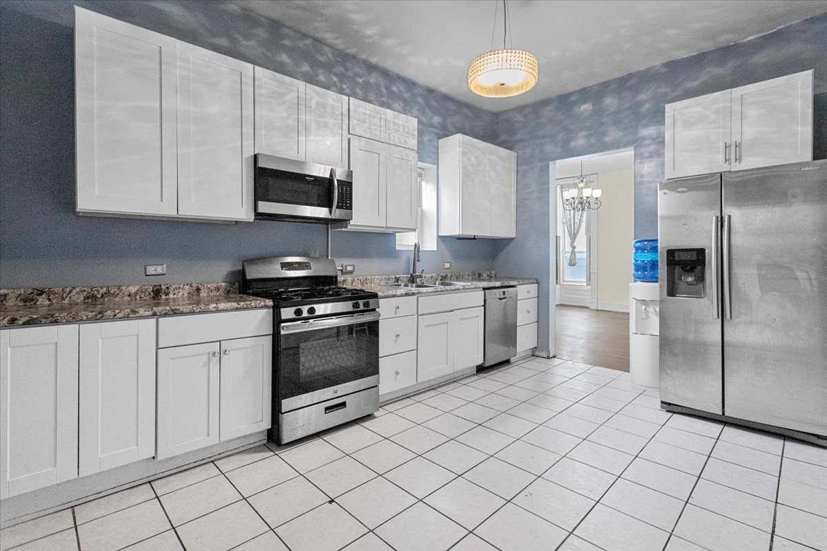 229 South Racine Avenue, Unit 1 Chicago, IL 60607 - Photo 2 of 10 a kitchen with a stove a sink and a refrigerator