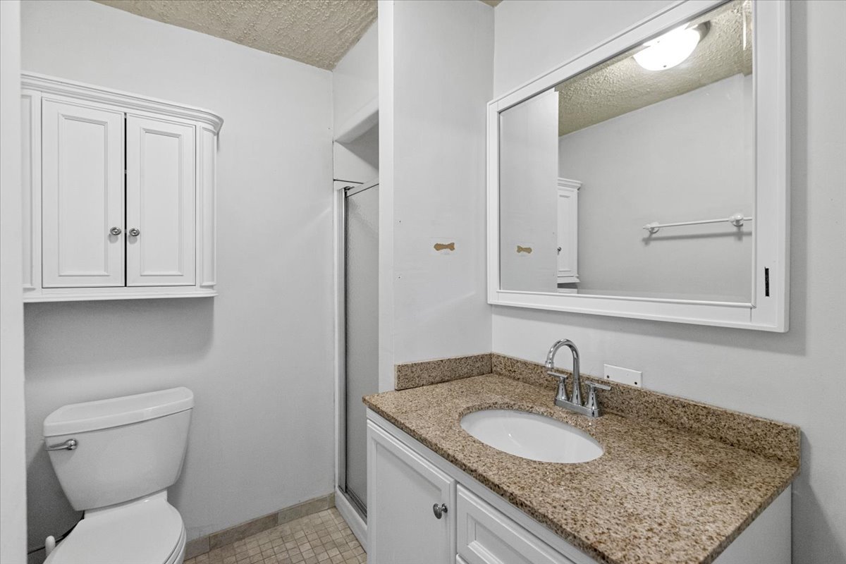 229 South Racine Avenue, Unit 1 Chicago, IL 60607 - Photo 10 of 10 a bathroom with a granite countertop toilet sink and mirror