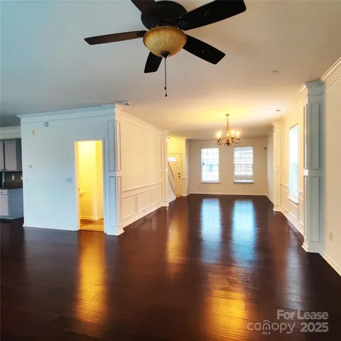 a view of an empty room with window and wooden floor