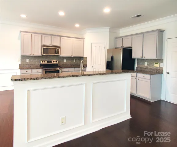 a kitchen with stainless steel appliances a refrigerator stove microwave and sink