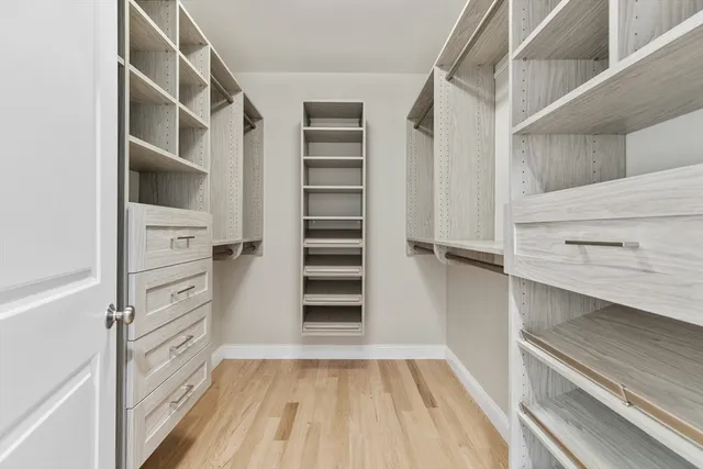 a view of walk in closet with empty racks