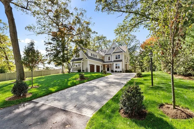 a front view of a house with a garden and tree