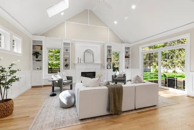 a living room with fireplace furniture and a large window