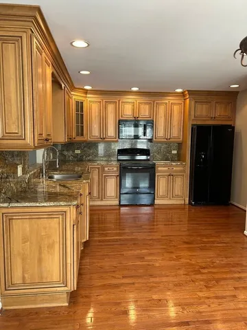 a kitchen with stainless steel appliances granite countertop a stove a sink and a refrigerator