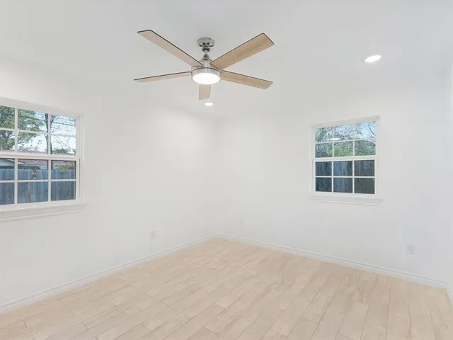 an empty room with a window and a fan