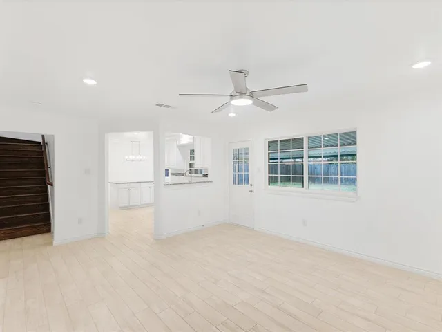 an empty room with cabinet and windows