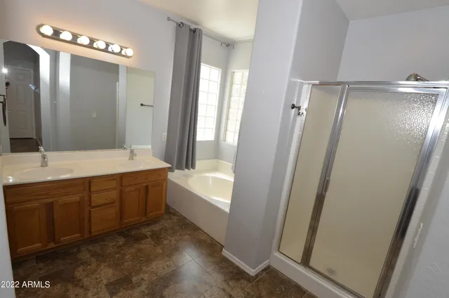 a bathroom with double vanity and a bathtub