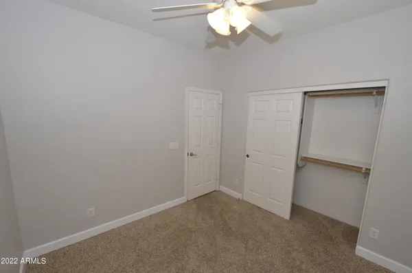 an empty room with a chandelier fan