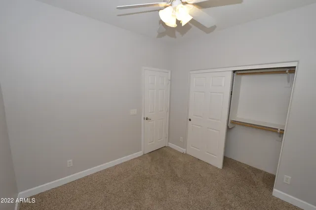 an empty room with a chandelier fan