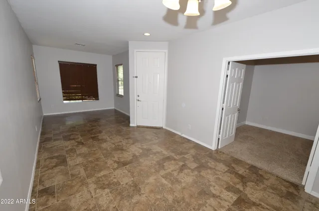 an empty room with an entryway and closet