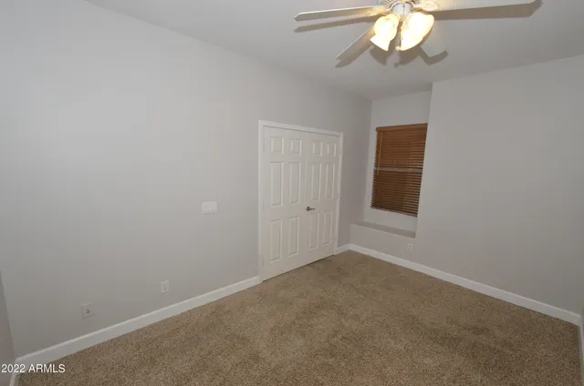 en empty room with a chandelier fan and a chandelier fan