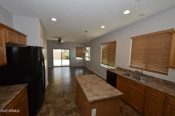 a kitchen with stainless steel appliances granite countertop a refrigerator a sink dishwasher a stove and a refrigerator with wooden floor