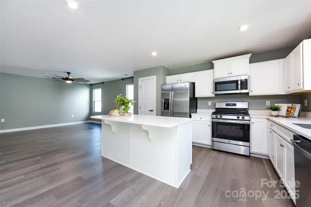 a kitchen with granite countertop a stove top oven and cabinets
