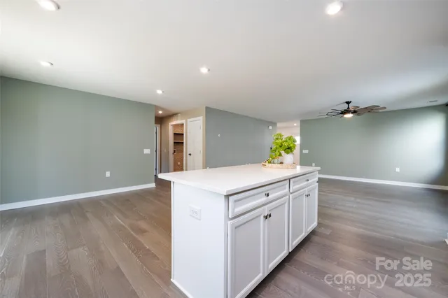 a kitchen with a stove and wooden floor