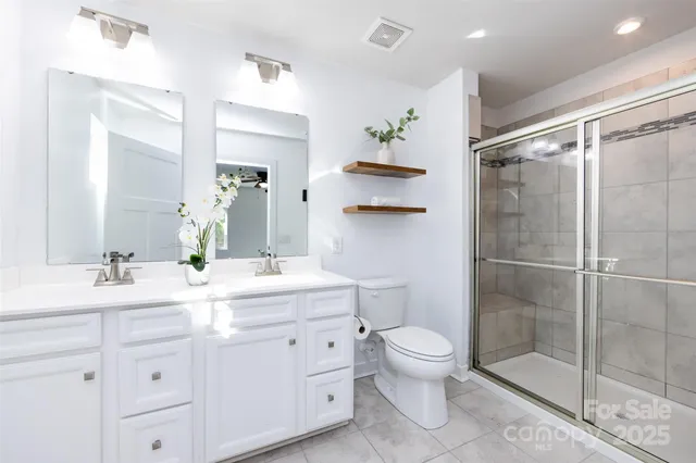 a bathroom with a double vanity sink toilet and shower