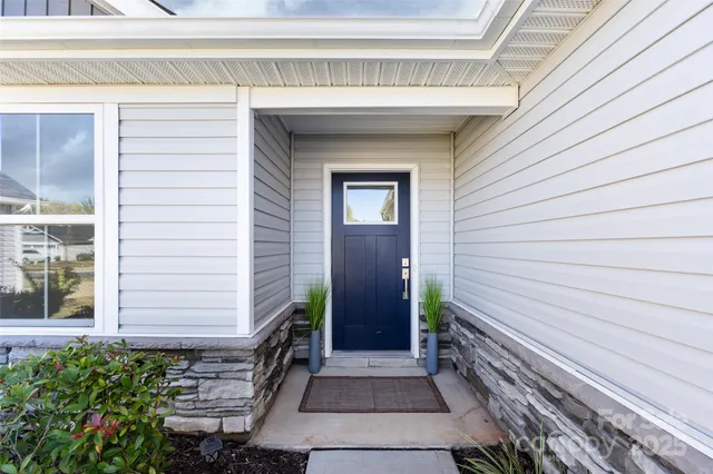 a view of a house with a door and wooden bench