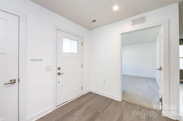 a view of an empty room with wooden floor