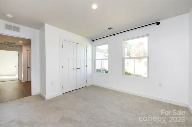 an empty room with windows and closet