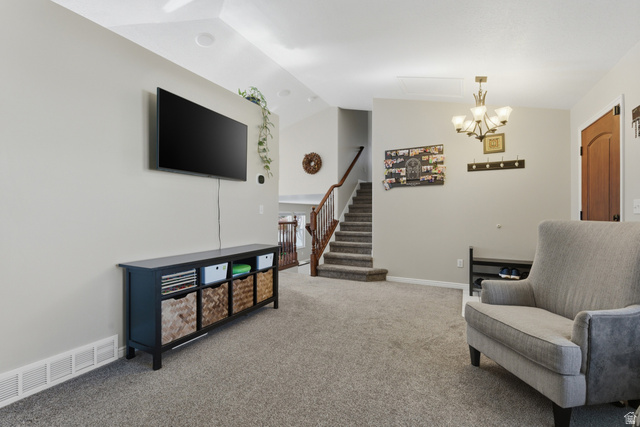 11189 Ohenry Road East Sandy, UT 84070 - Photo 7 of 44 Carpeted living area featuring a vaulted ceiling with recessed lighting, a chandelier, and a staircase with wood railings