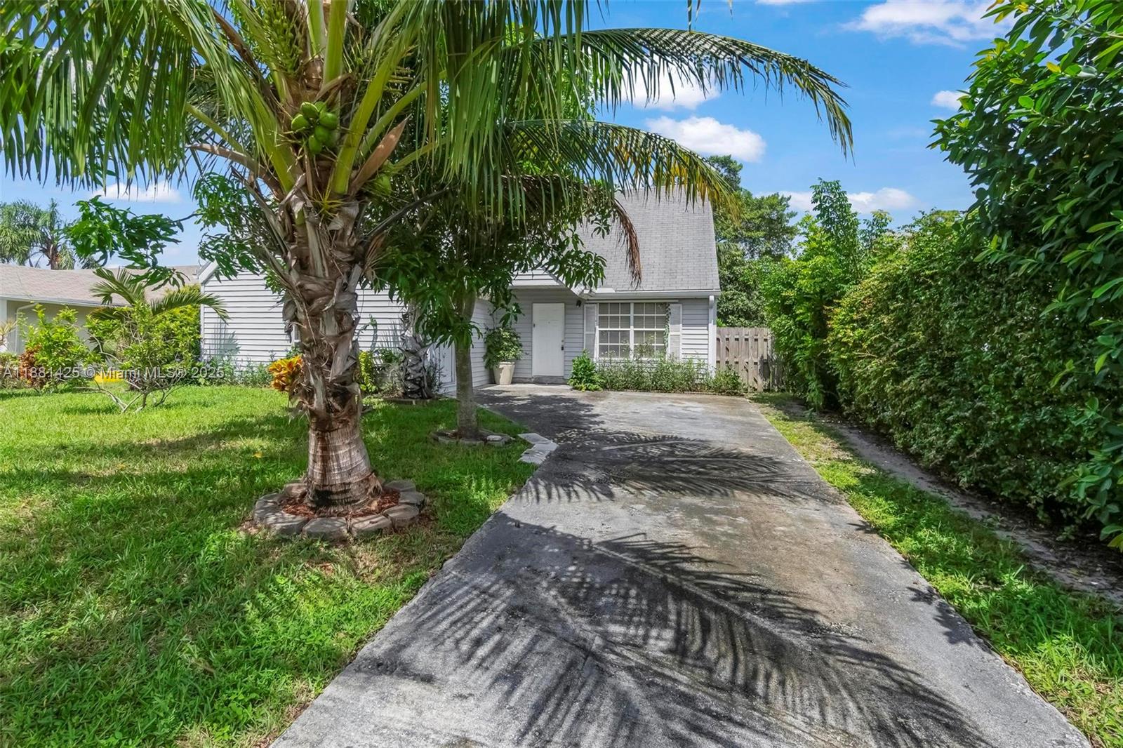 5119 Oak Hill Road Delray Beach, FL 33484 - Photo 2 of 48 a front view of a house with a garden